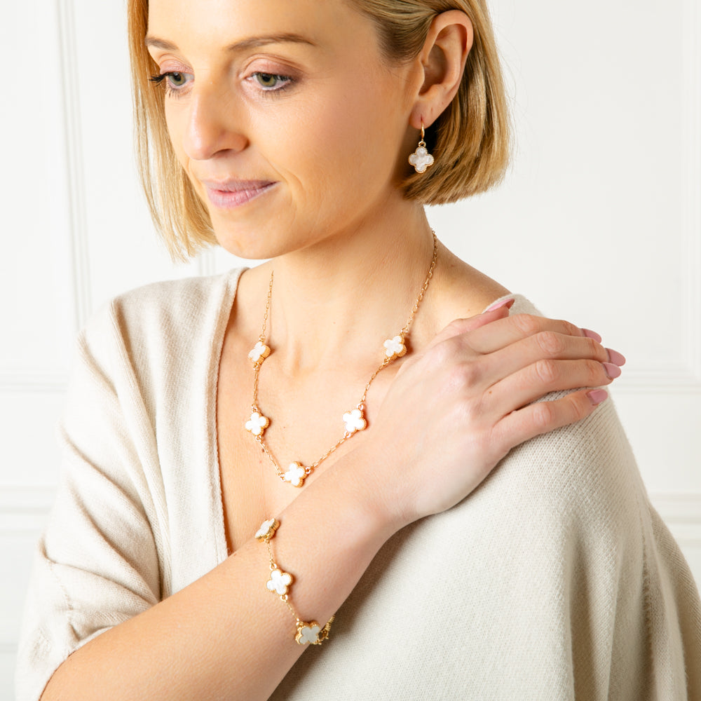 The white Ivy Jewellery collection as a short necklace, earrings and bracelet all in the classic clover shape